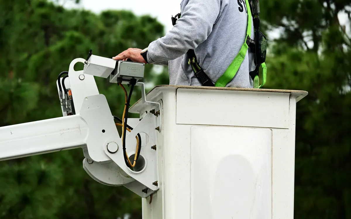 Operador con arnés trabajando desde una plataforma elevadora
